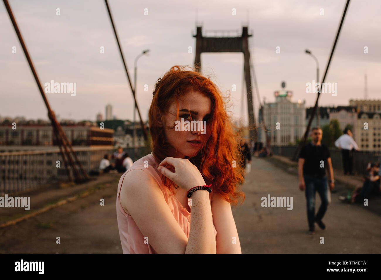 Portrait von nettes junges Mädchen mit roten Haaren steht auf der Brücke in der Stadt Stockfoto