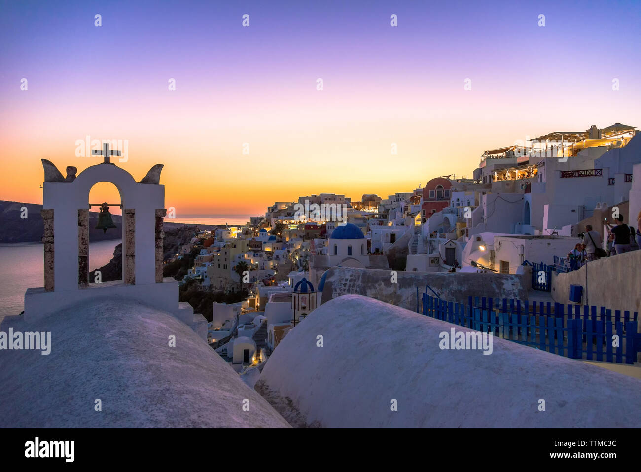 Ein Glockenturm der Kirche mit Blick auf Oia, Santorin nach Sonnenuntergang Stockfoto