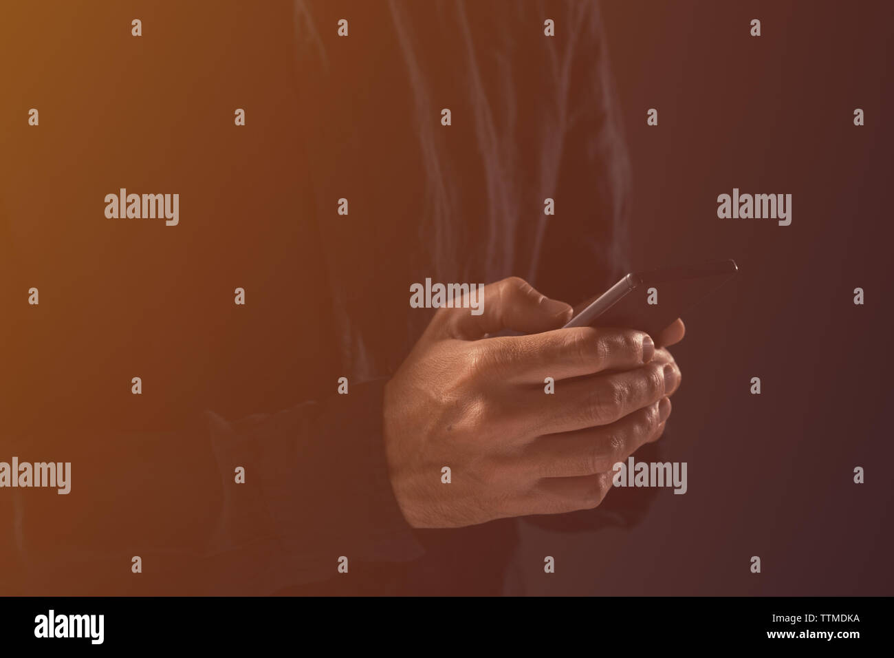 Kerl schreiben SMS auf Handy. Stattlichen erwachsenen Mann im schwarzen T-Shirt ist von SMS-Nachrichten auf dem Smartphone Gerät. Stockfoto