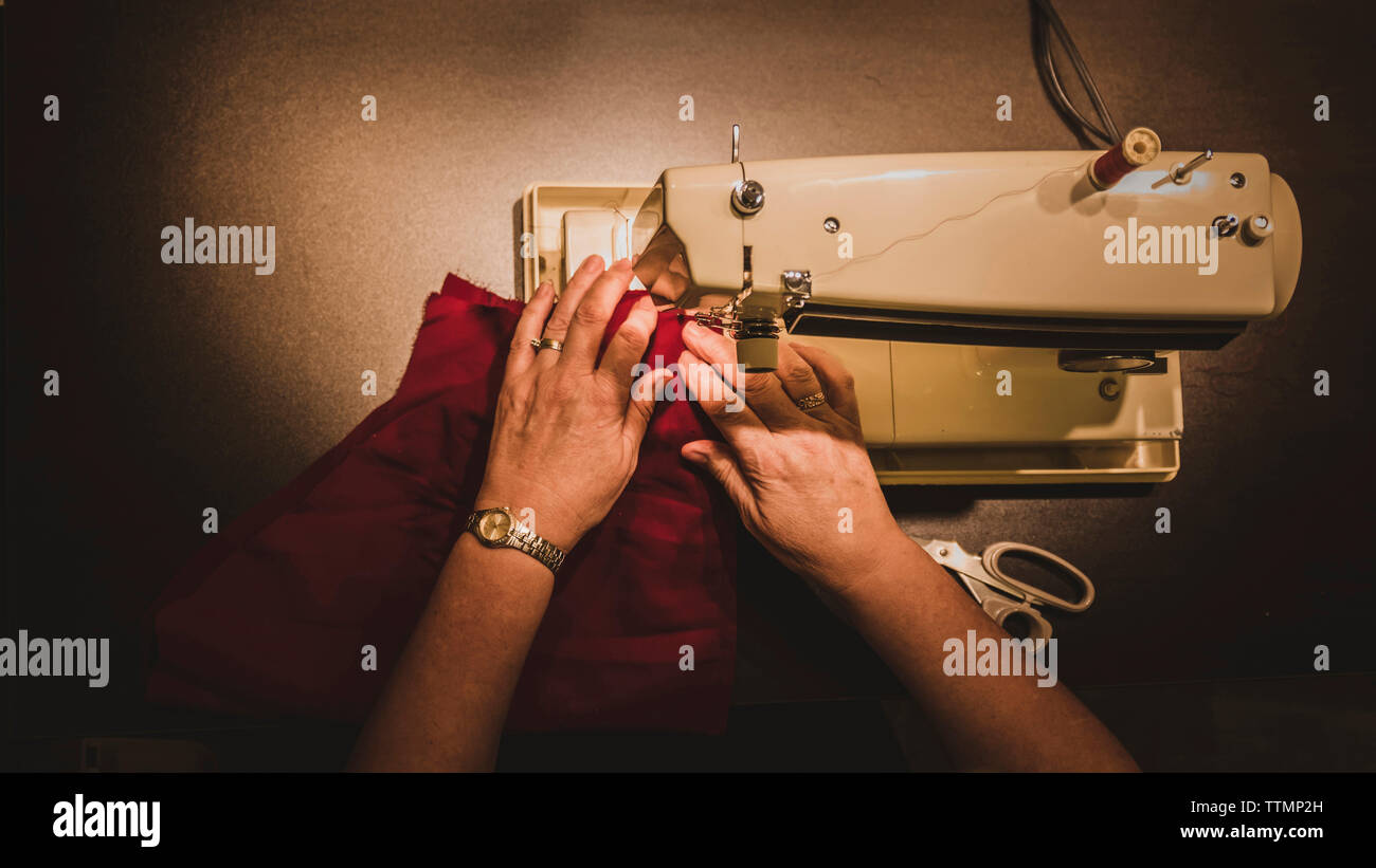 Hohen Winkel 7/8 Hand der Frau, die Nähmaschine zu Workshop Stockfoto