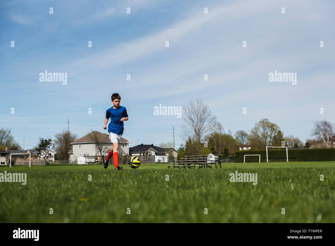 Oberfläche erschossen der Junge spielt Fußball auf der Wiese Stockfoto