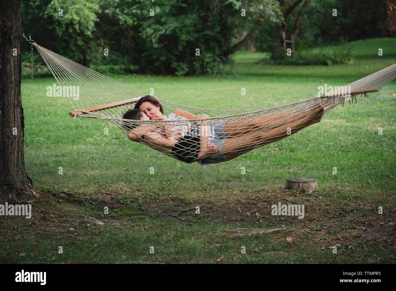 Mutter mit Sohn entspannen auf Hängematte im Wald Stockfoto