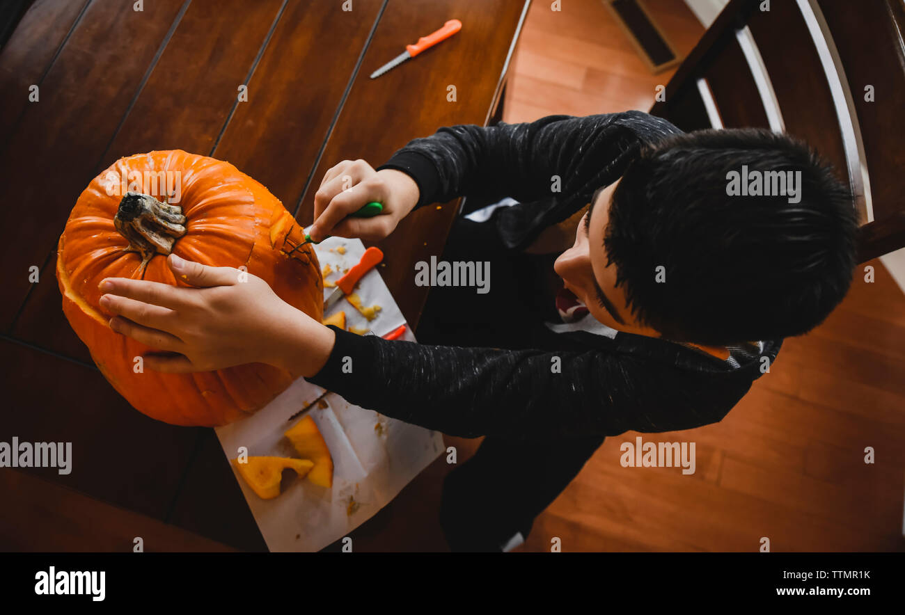 Hohe Betrachtungswinkel und der Boy, Jack O'Lantern zu Hause während Halloween Stockfoto
