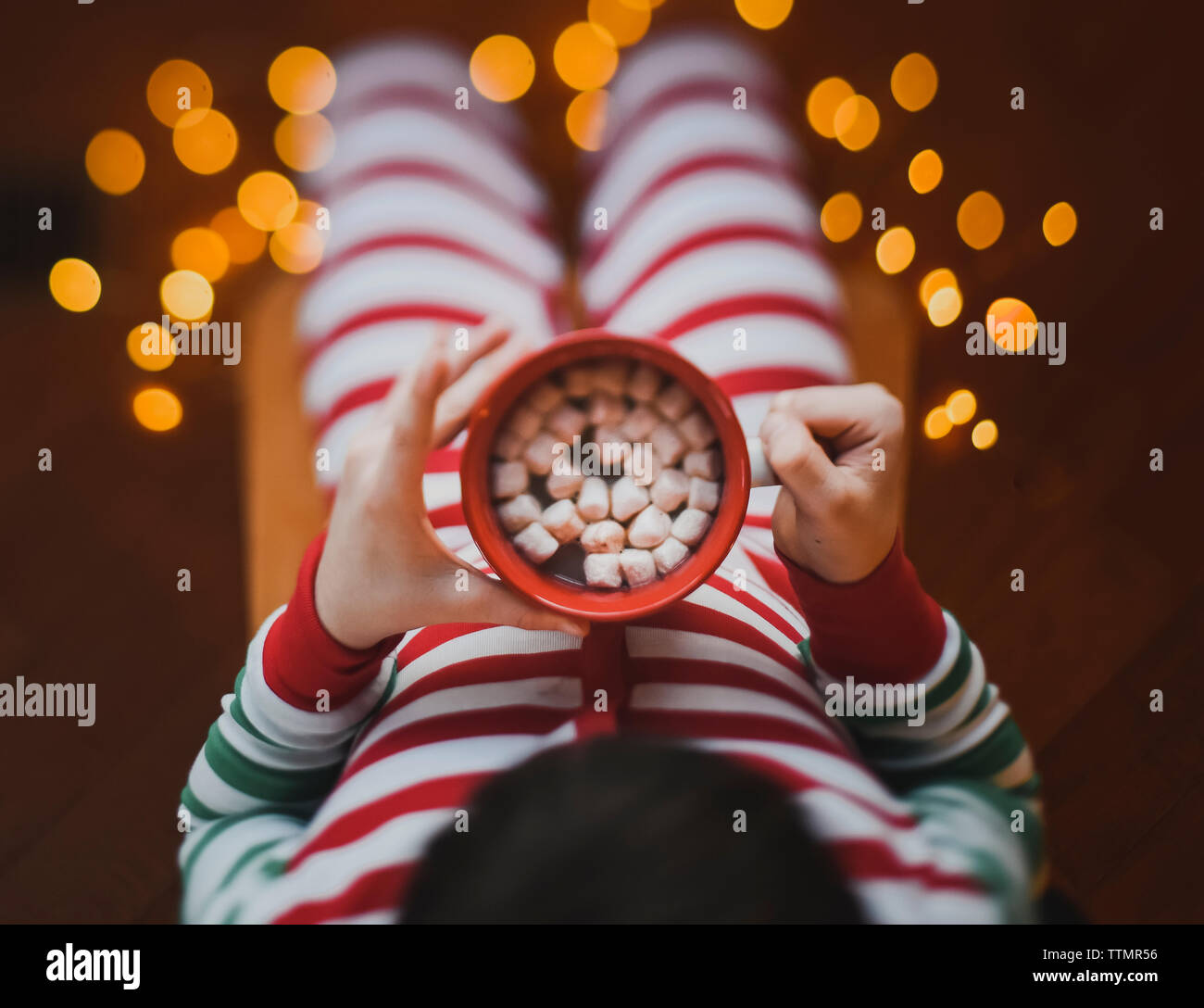 Kind tragen Weihnachten pjs hält Tasse heißen Kakao mit marshmalows. l Stockfoto