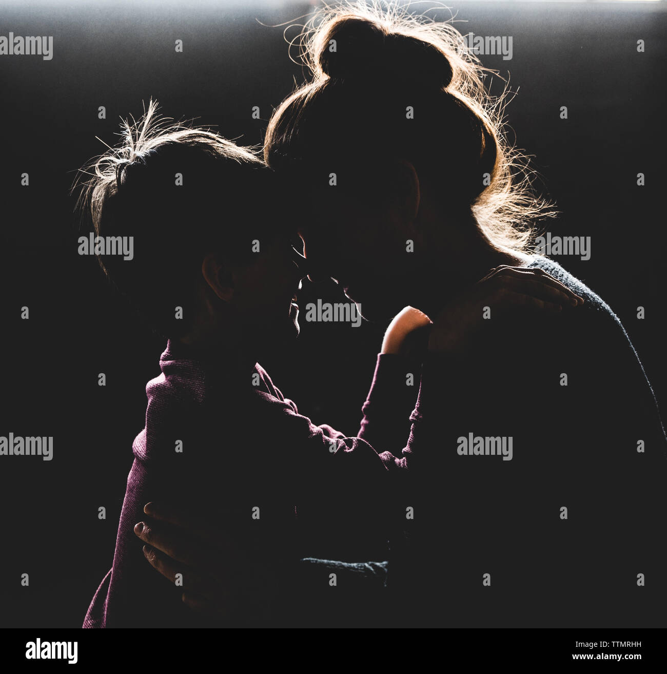 Hintergrundbeleuchtung Portrait von Mutter und Sohn mit Köpfe zusammen lächeln. Stockfoto