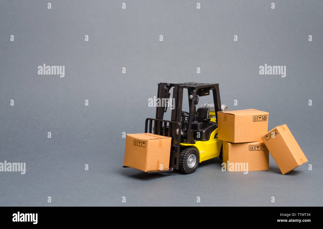 Gelbe Gabelstapler mit Kartons. Vertrieb, Produktion von Gütern. Transport, Lagerung von Gütern und Waren zu erhöhen. Fracht, liefern Stockfoto