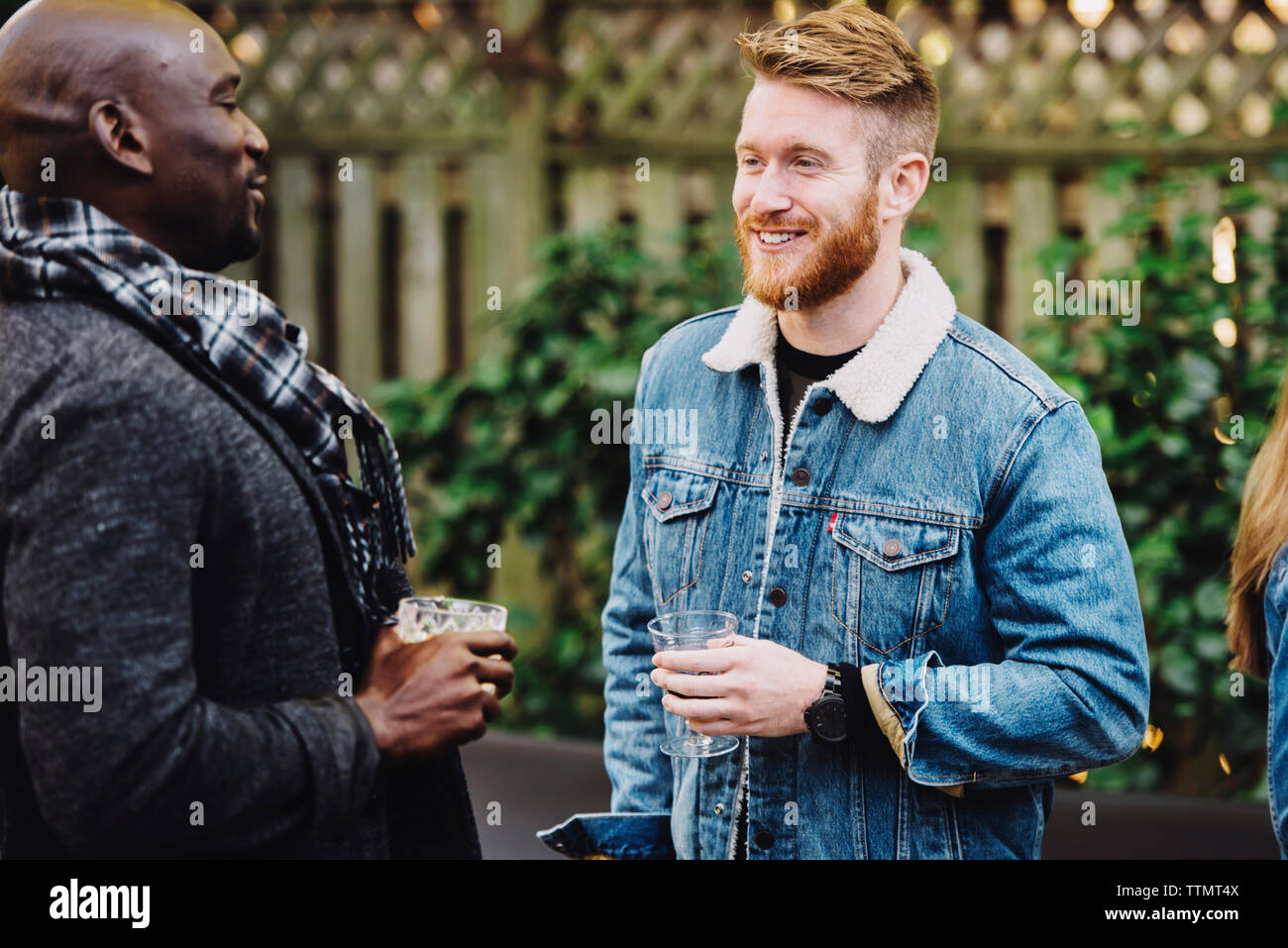 Freunde sprechen, während sie Getränke im Hinterhof Stockfoto