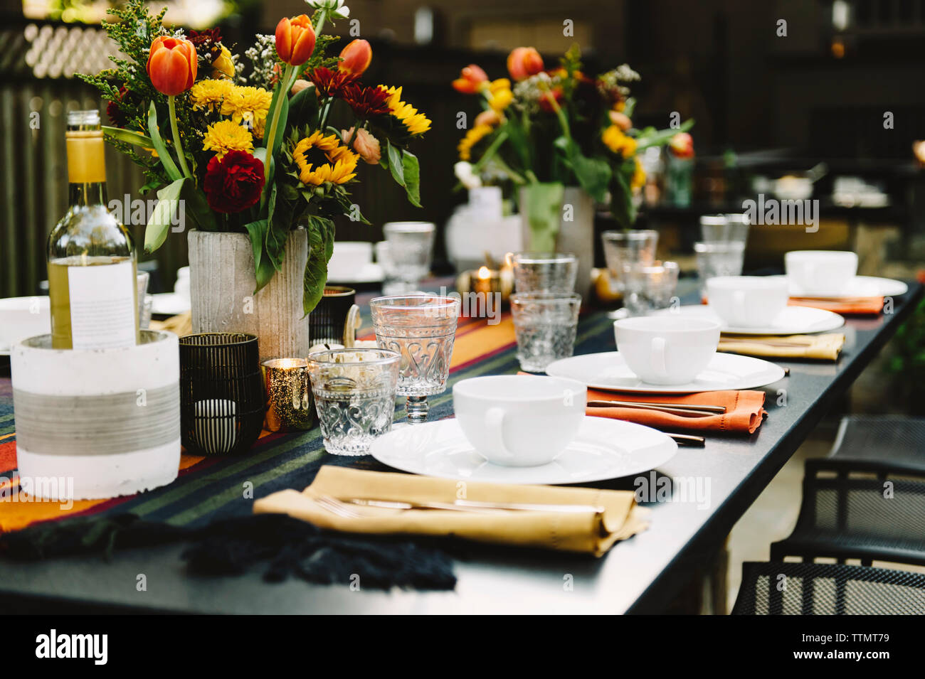 Blumenvasen mit Geschirr auf dem Tisch im Hinterhof angeordnet Stockfoto