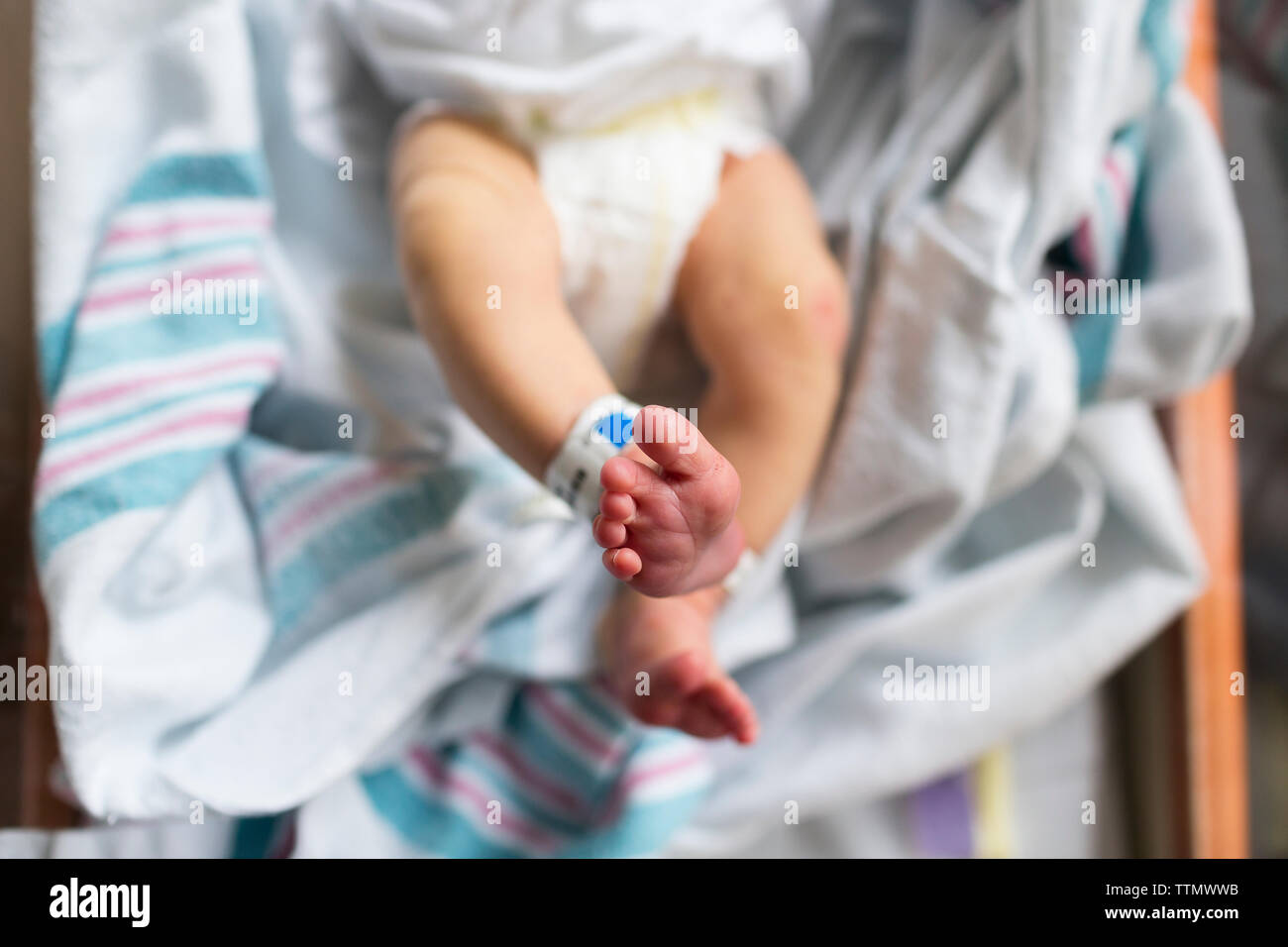 Overhead Neugeborenen Füße im Krankenhaus Korbwiege, Stretching Beine Stockfoto