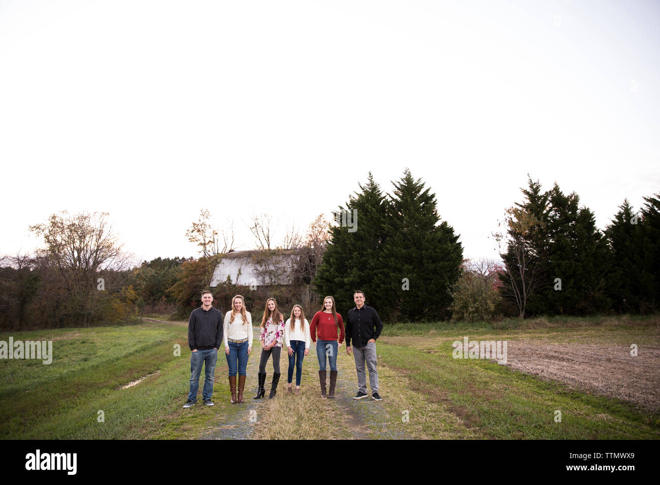 Weiten Blick über grosse, glückliche Familie Vor der alten Scheune stehen im Feld Stockfoto
