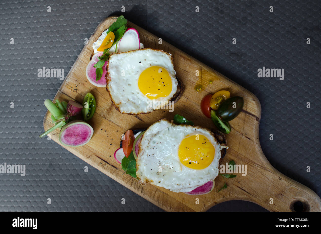 Hohe Betrachtungswinkel von Spiegeleier mit Brot und Gemüse auf dem Board Stockfoto