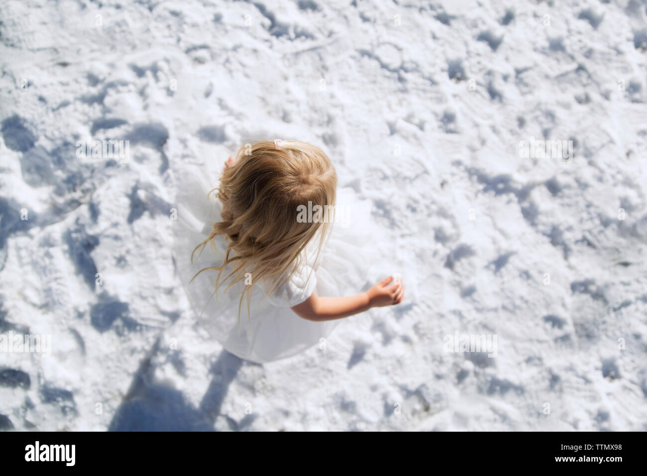 Ansicht von oben von Mädchen zu Fuß auf schneebedeckten Feld Stockfoto