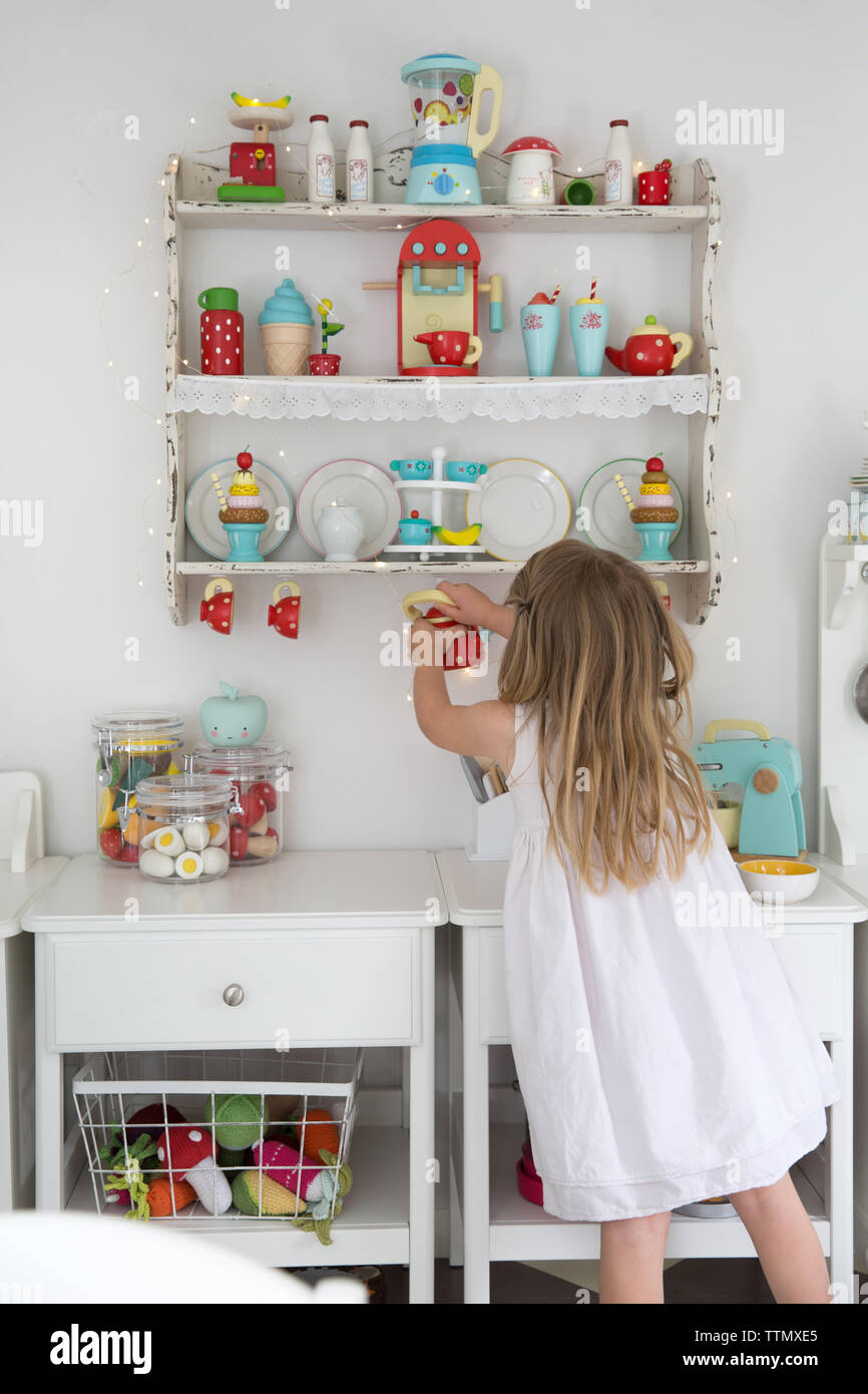 Ansicht der Rückseite des Girl holding Teekanne beim Spielen in playhouse Stockfoto