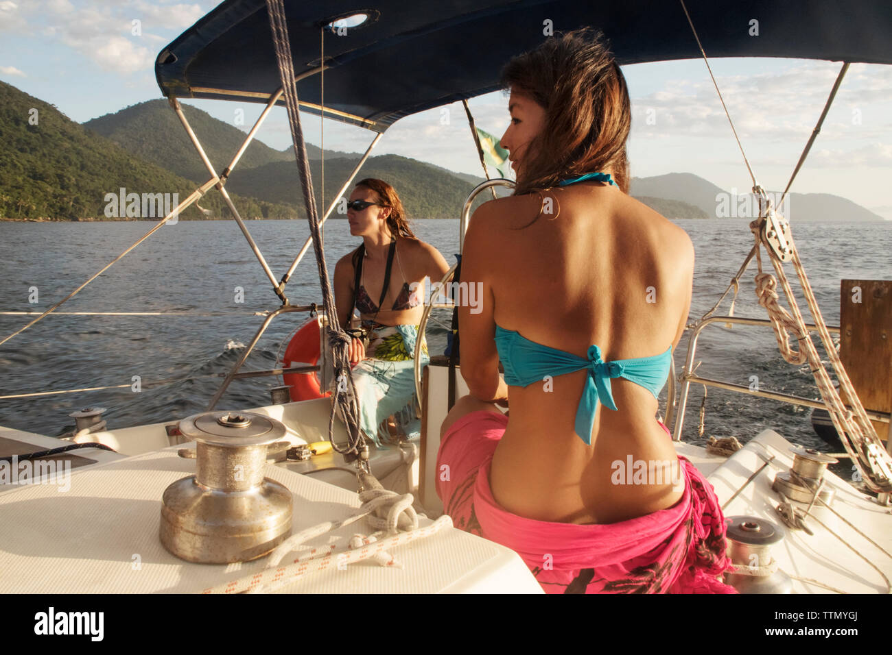 Freunde Reiten auf Boot im Meer gegen Berge Stockfoto