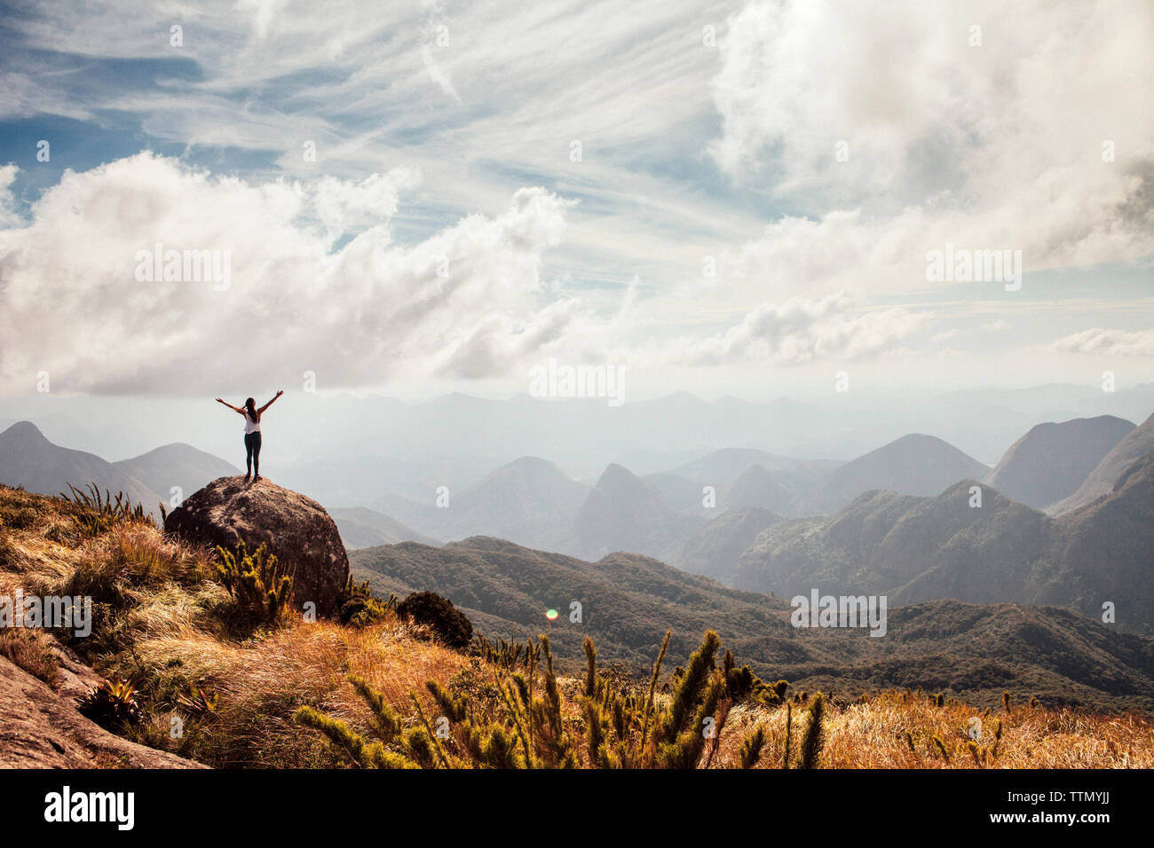 Sicht der weiblichen Wanderer stehen mit ausgestreckten Armen auf dem Berg gegen bewölkter Himmel Stockfoto
