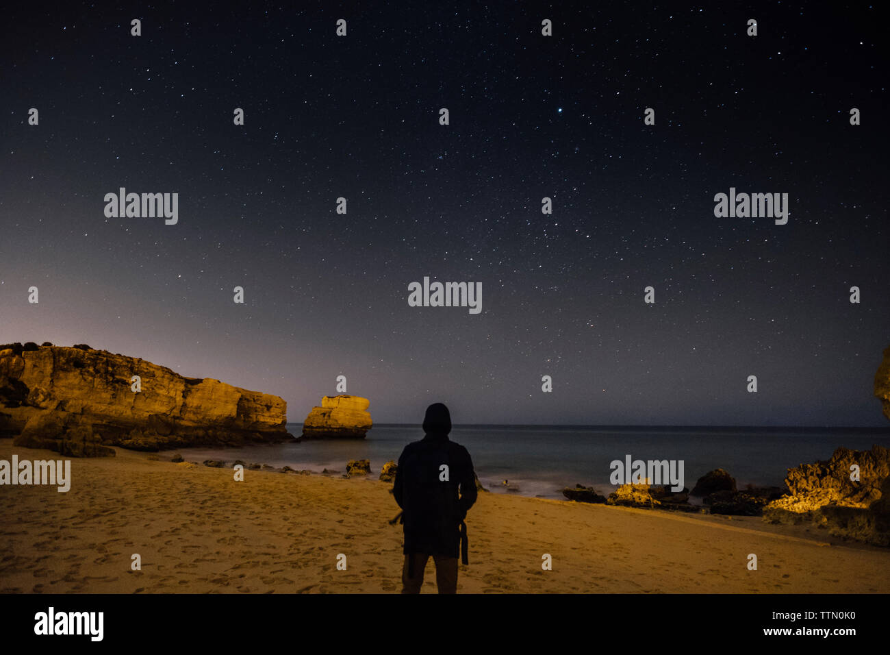 Ansicht der Rückseite des Silhouette Mann stand am Strand gegen star Feld in der Nacht Stockfoto