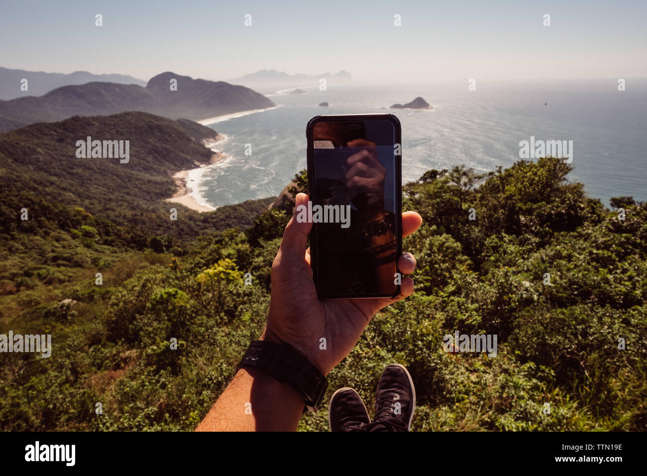 Man nimmt ein Foto von dem Zimmer mit Blick auf den Ozean und ein Telefon in Rio de Janeiro Stockfoto