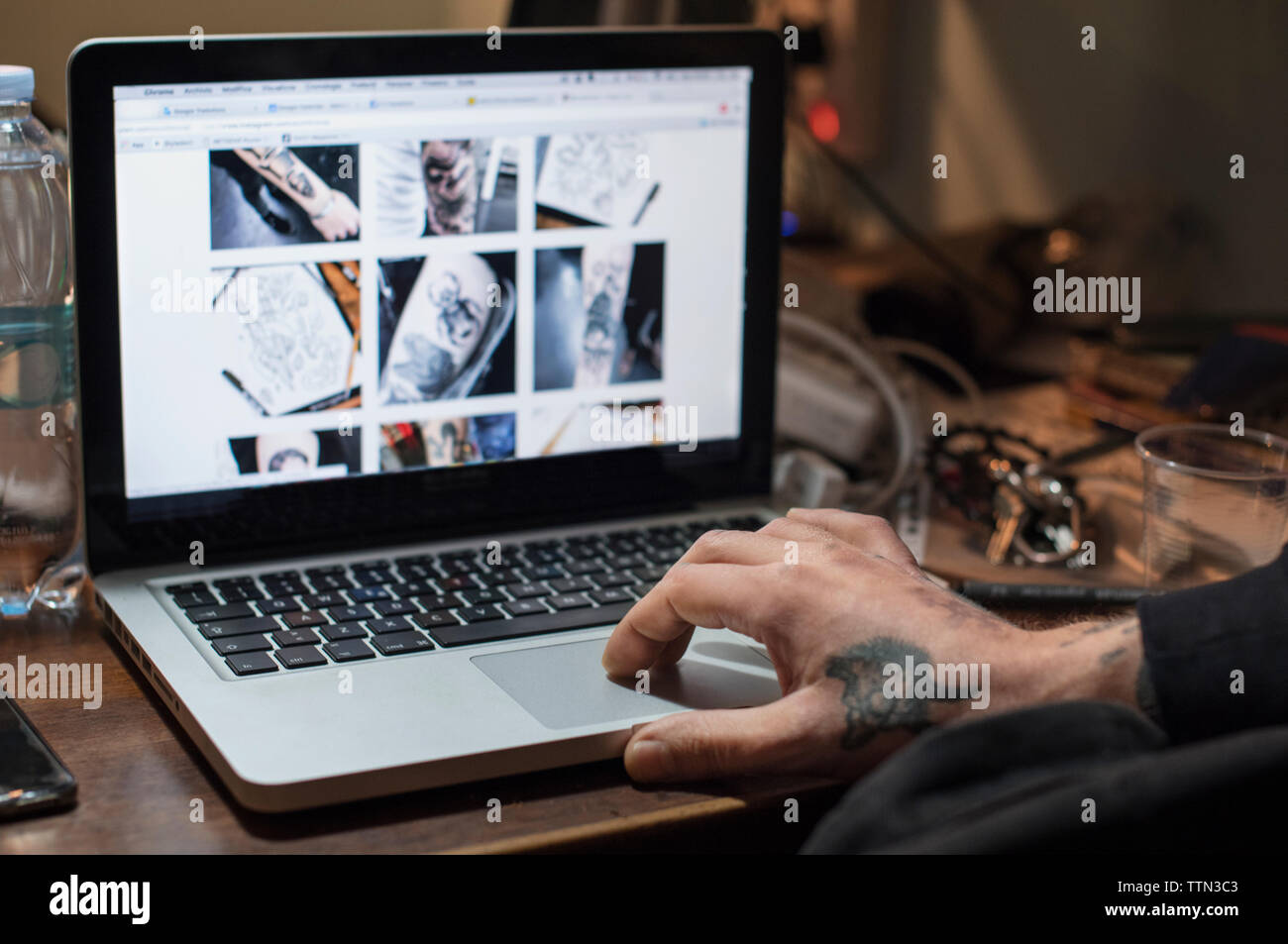 Zugeschnittenes Bild der Tätowierer mit Laptop im Studio Stockfoto