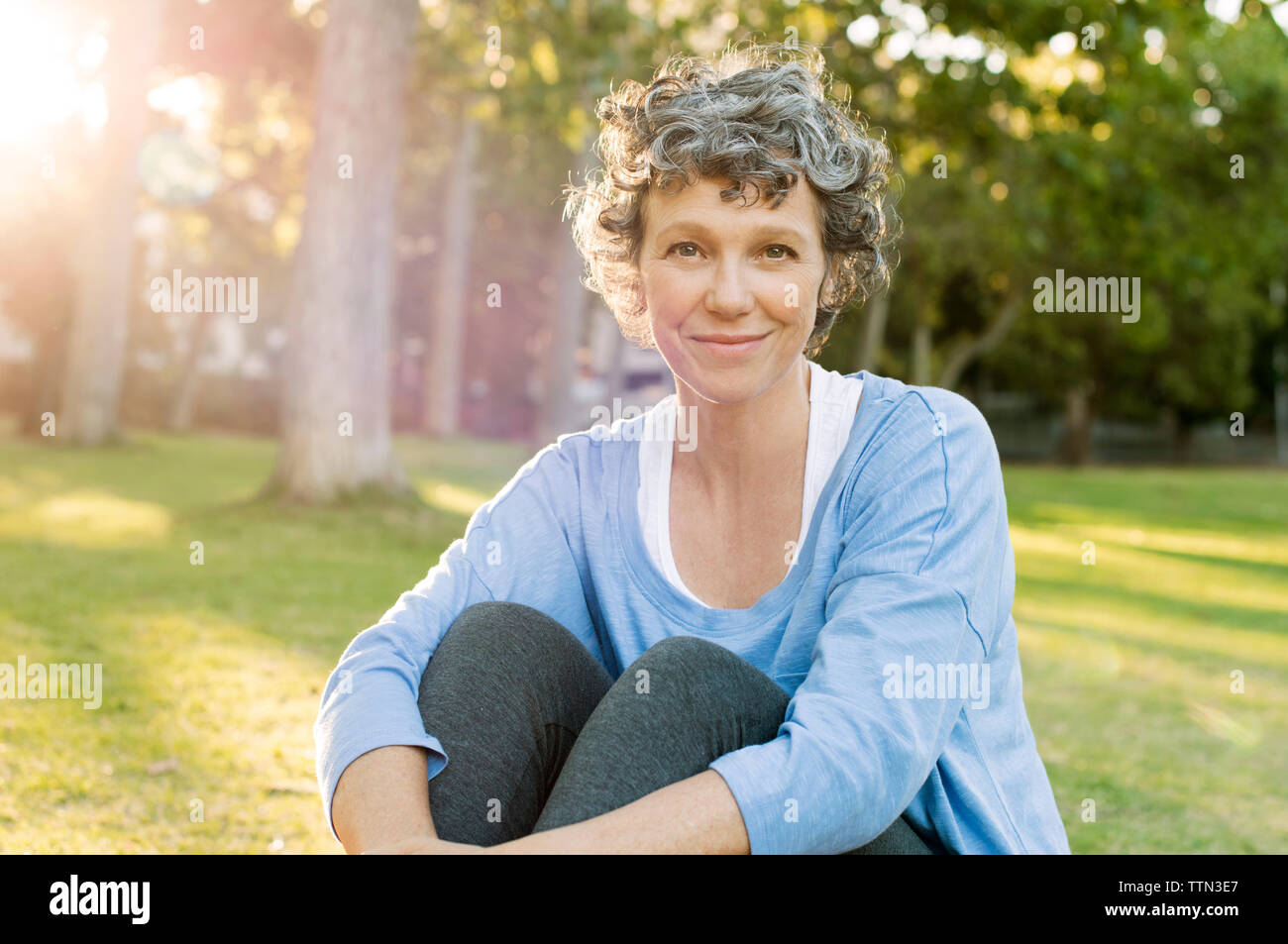 Portrait von reife Frau sitzen auf dem Feld Stockfoto