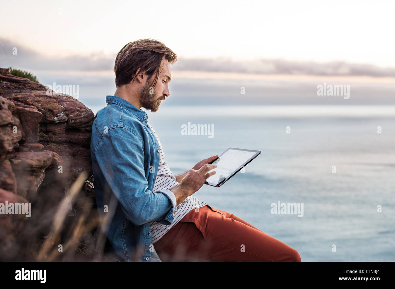 Seitenansicht des Menschen mit Tablet-PC auf dem Seeweg Stockfoto
