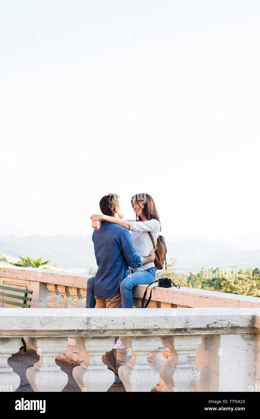 Romantisches Paar Umarmung auf der Terrasse gegen den klaren Himmel Stockfoto