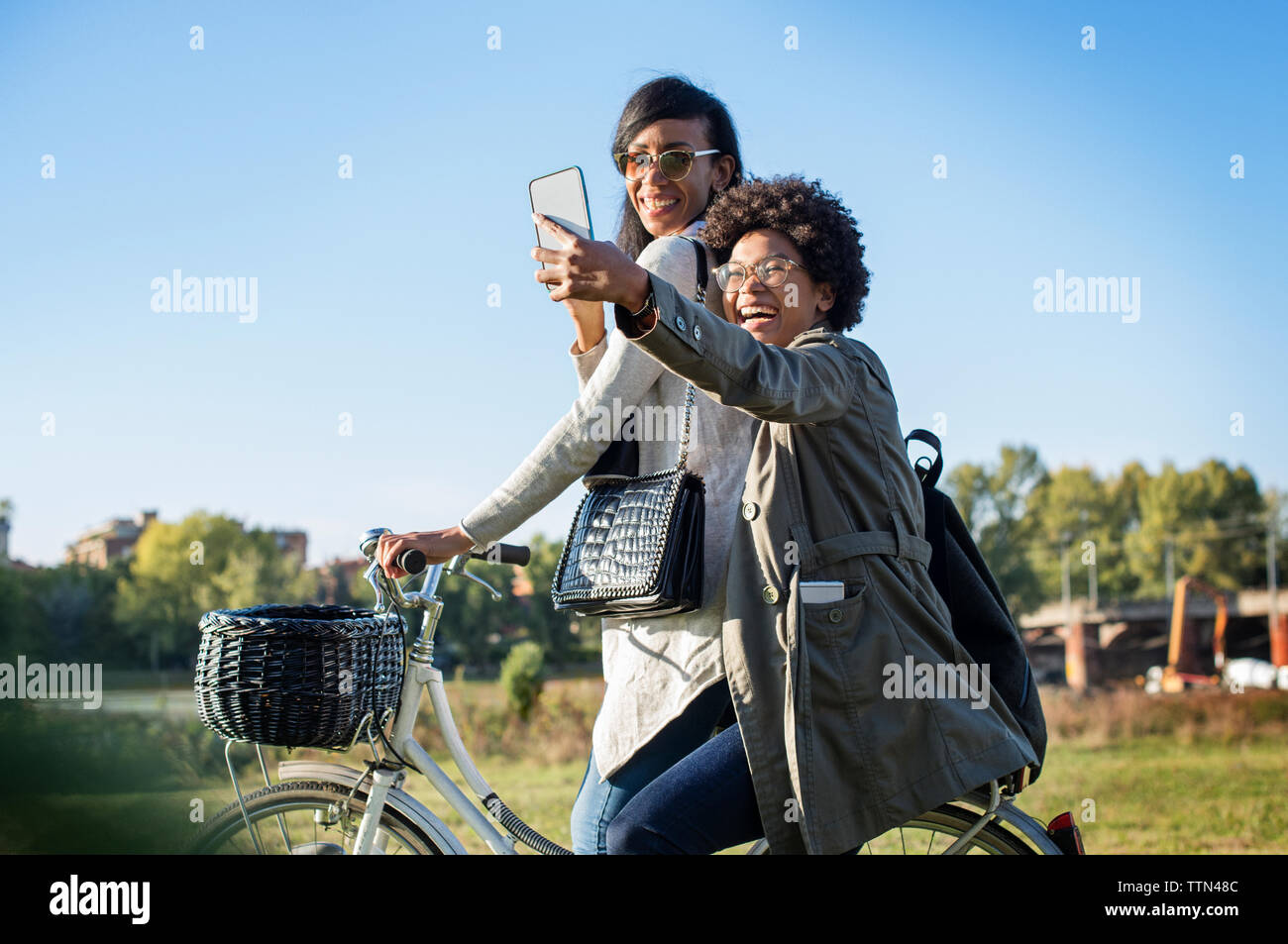 Gerne Freunde unter selfie per Telefon beim Reiten Fahrrad auf Feld Stockfoto
