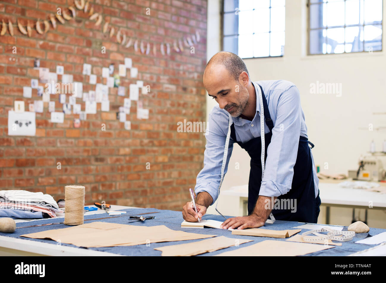 Männliche Fashion Designer bei Tisch Arbeiten in der Werkstatt Stockfoto