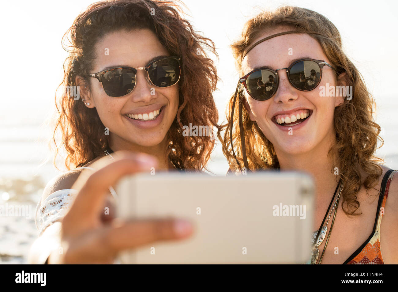 Gerne weibliche Freunde unter selfie am Strand Stockfoto