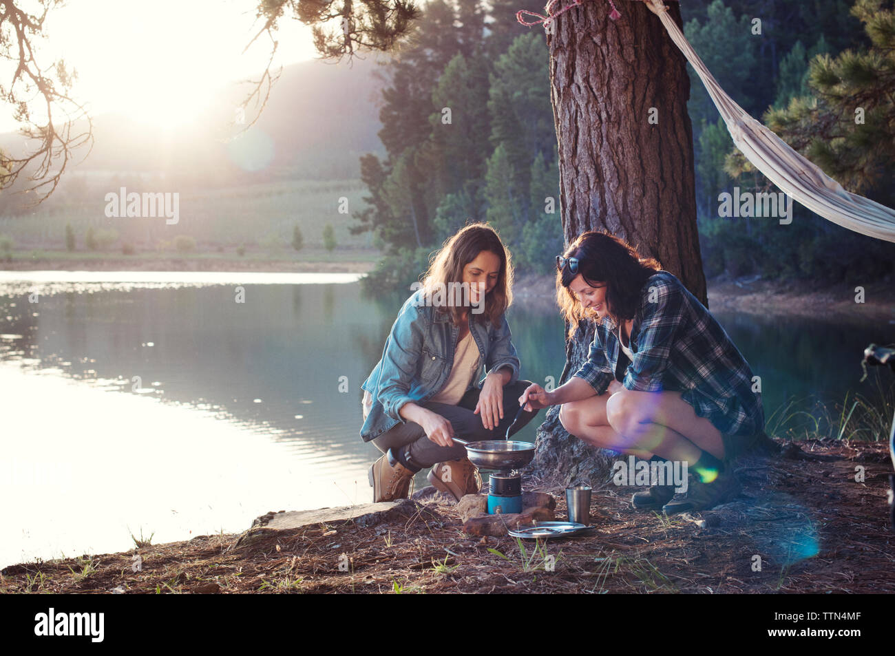 Weibliche Freunde, Essen von See am Campingplatz Stockfoto
