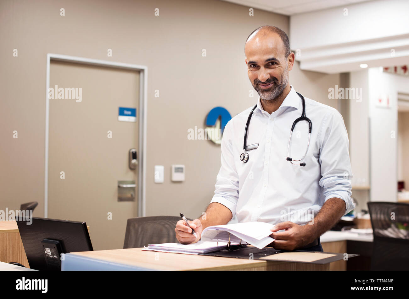 Portrait von Arzt mit der Vorbereitung von Berichten während der Arbeit im Krankenhaus Stockfoto