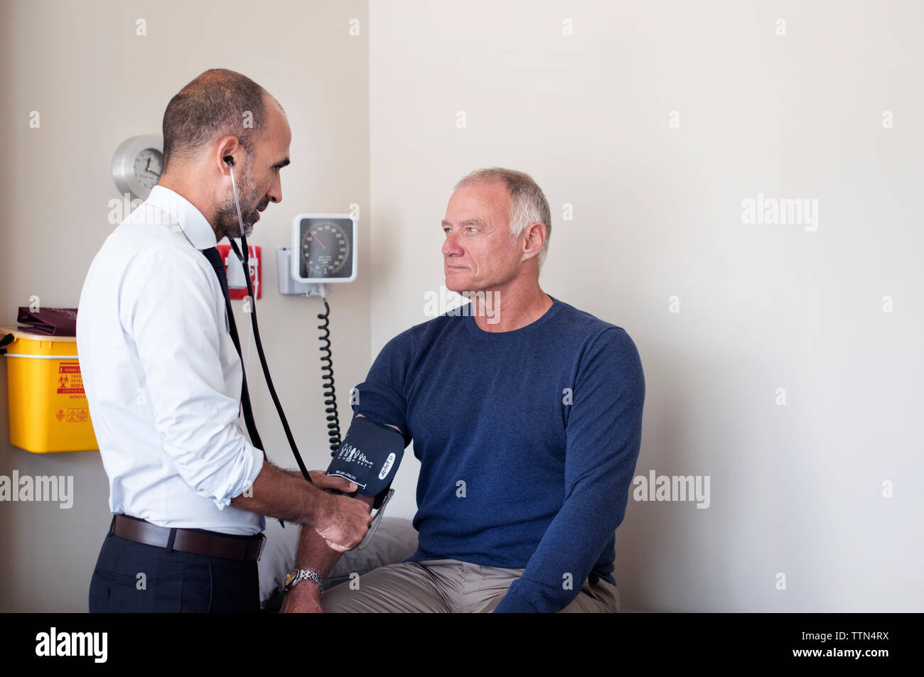 Arzt Kontrolle Blutdruck des Patienten im Untersuchungsraum Stockfoto