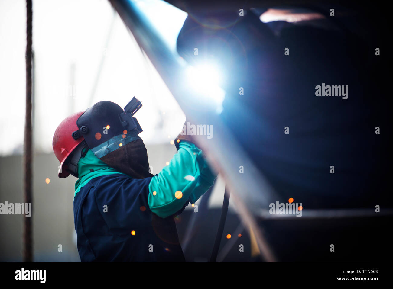 Seitenansicht des Arbeitnehmers schweißen Containerschiff an die Industrie Stockfoto