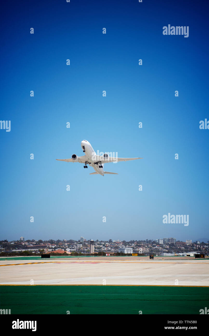 Low Angle View von Flugzeug weg vom Flughafen gegen blauen Himmel Stockfoto