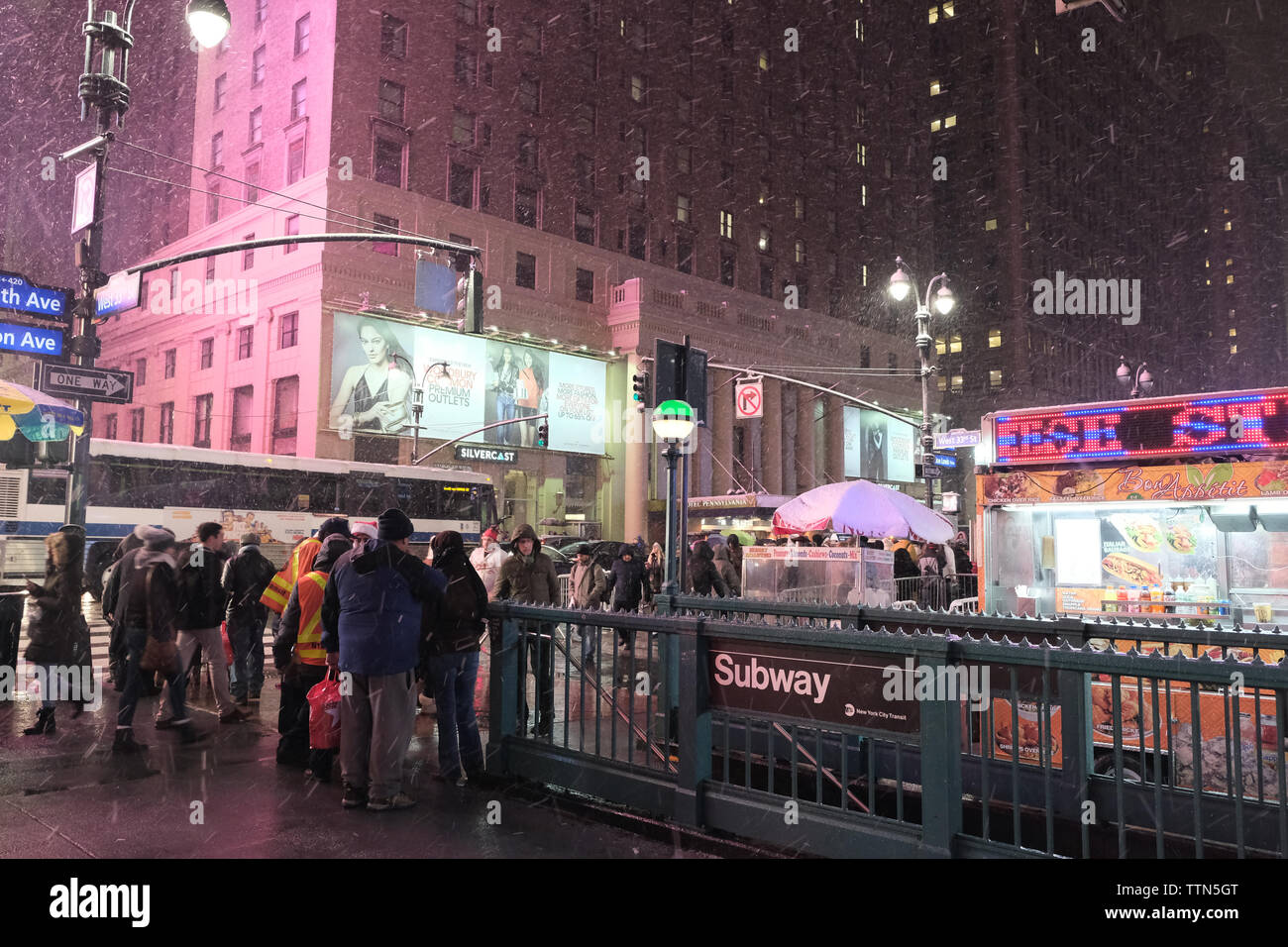 Pendler stehen außerhalb einer New Yorker U-Bahn Station in New York City während eines Schneesturms an der 7th Avenue in New York City, New York, USA Stockfoto
