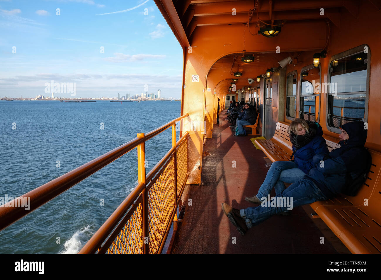 Dezember 2017 - Passagiere an Bord der kostenlosen Staten Island Ferry in New York City. Manhattan kann im Hintergrund, NY, USA Stockfoto