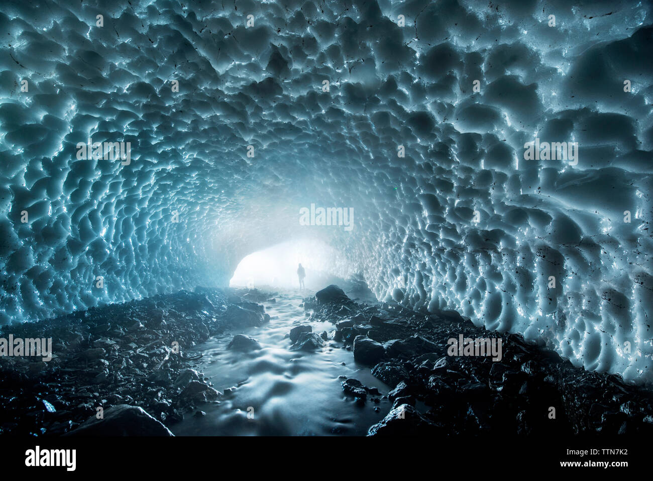Mitte der Abstand der Silhouette Mann in Eishöhle Stockfoto