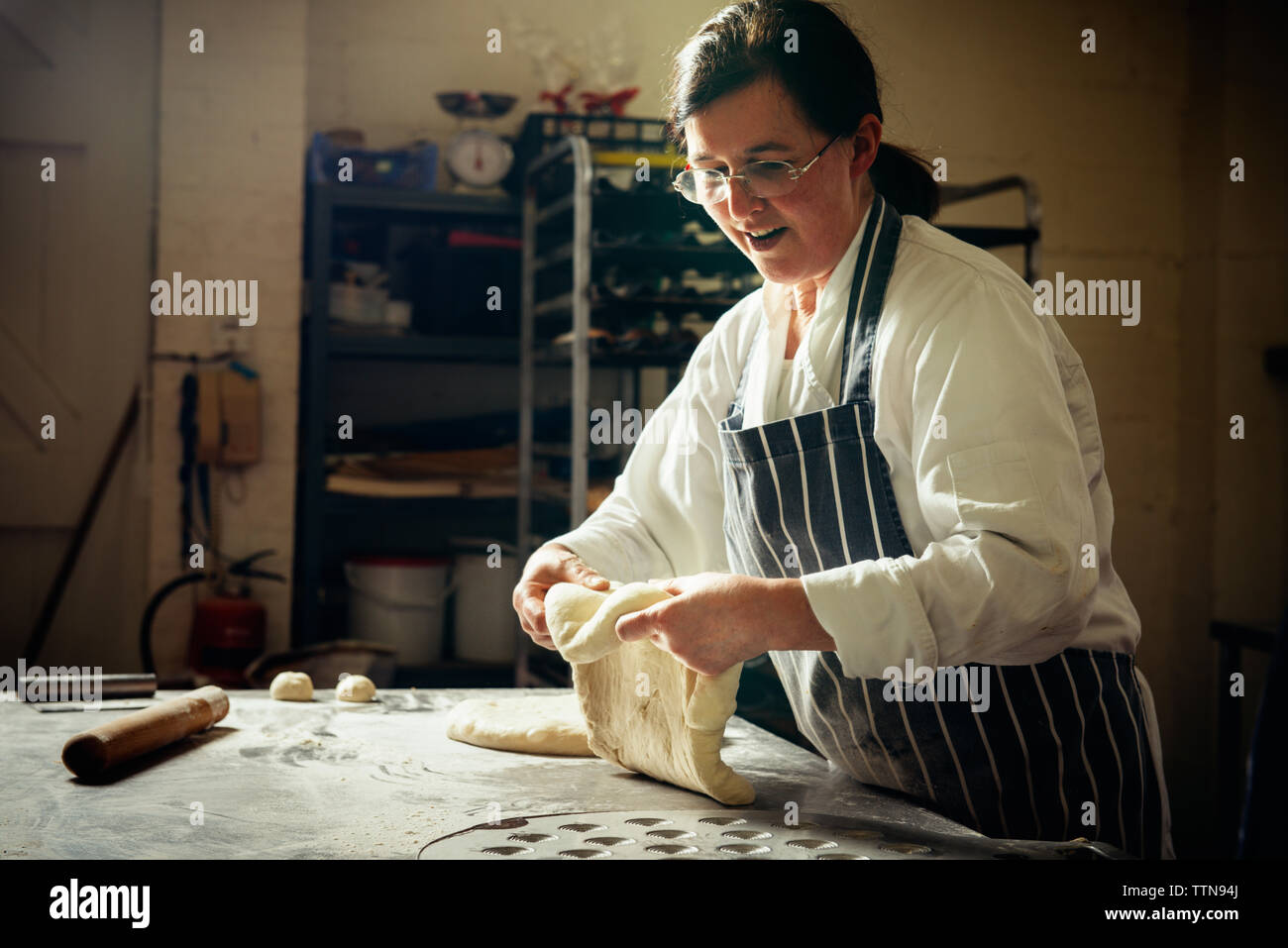 Weibliche baker Vorbereitung Brotteig in der gewerblichen Küche Stockfoto