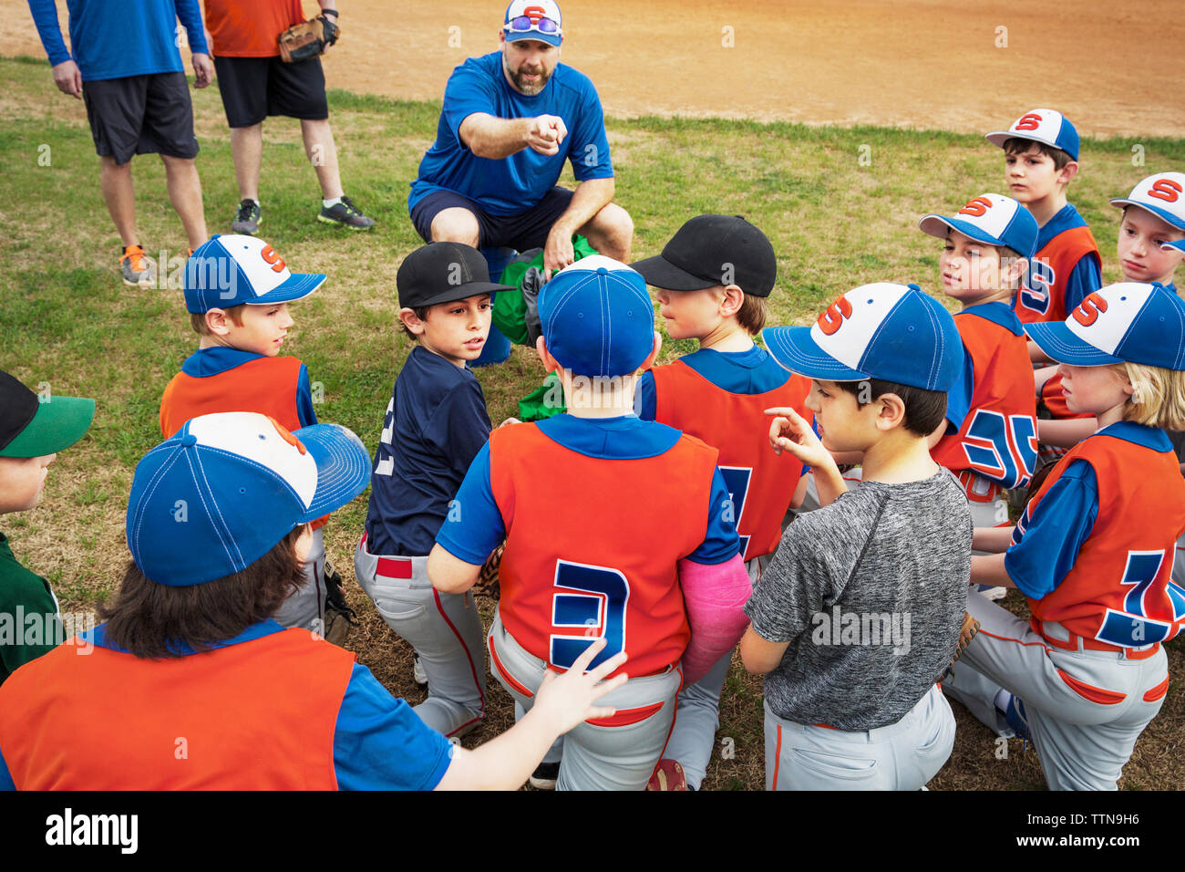Baseball Trainer unterrichten Jungen auf Feld Stockfoto