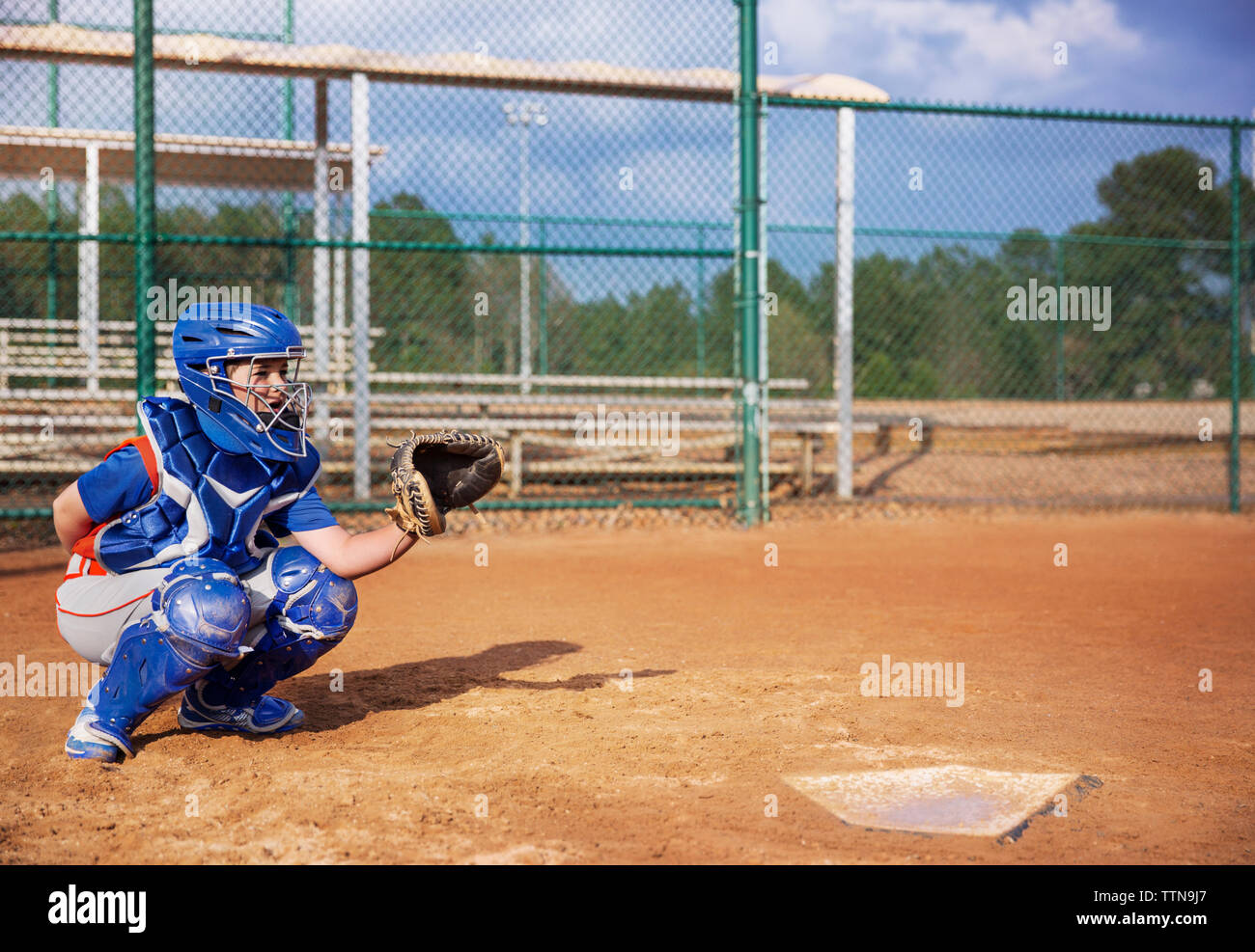 Baseball Catcher zusammengekauert auf dem Feld Stockfoto