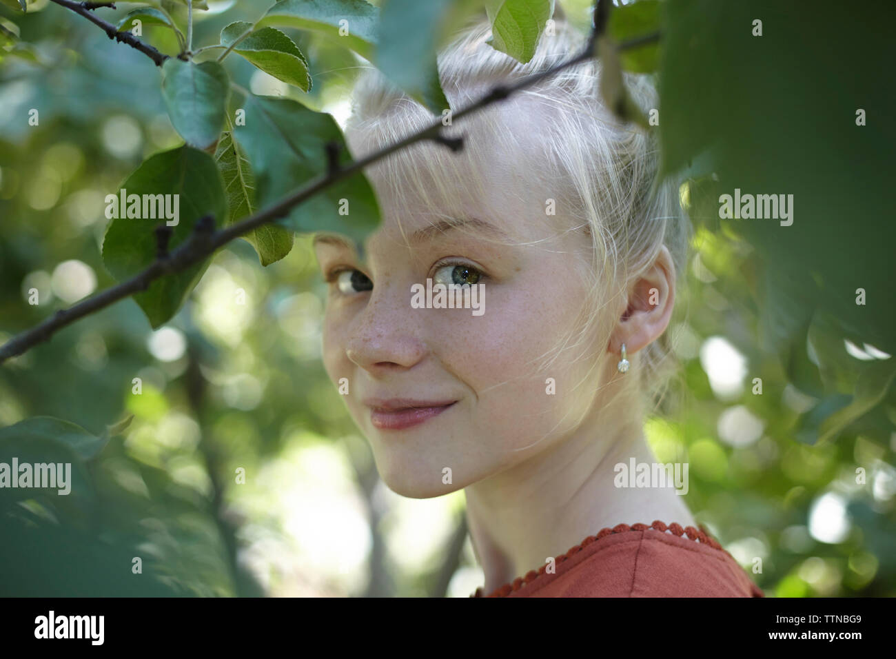 Portrait von selbstbewusste Frau inmitten von Bäumen Stockfoto