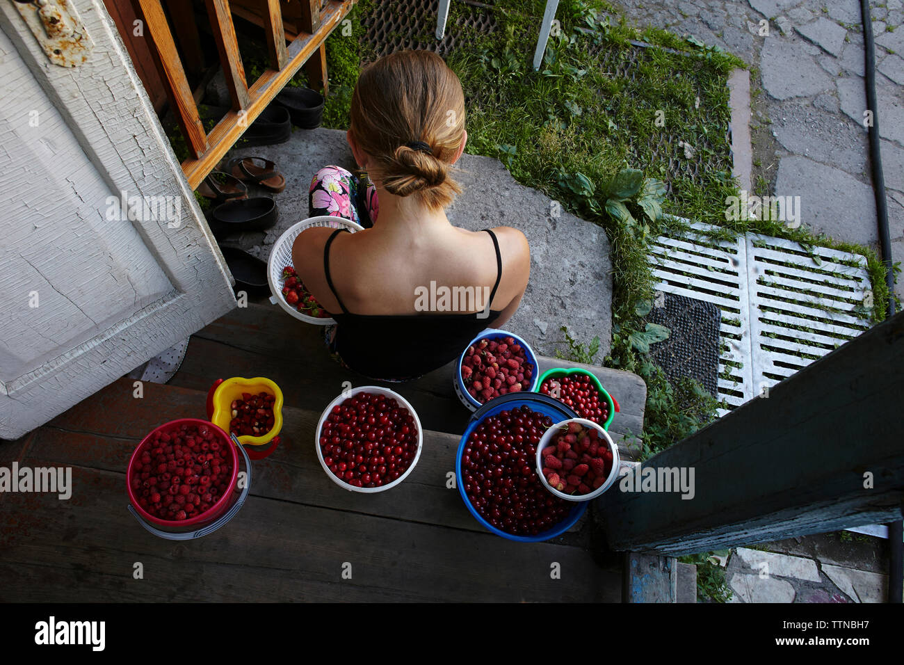 Hohe Betrachtungswinkel und der Frau mit Früchten in Containern an der Tür sitzen Stockfoto