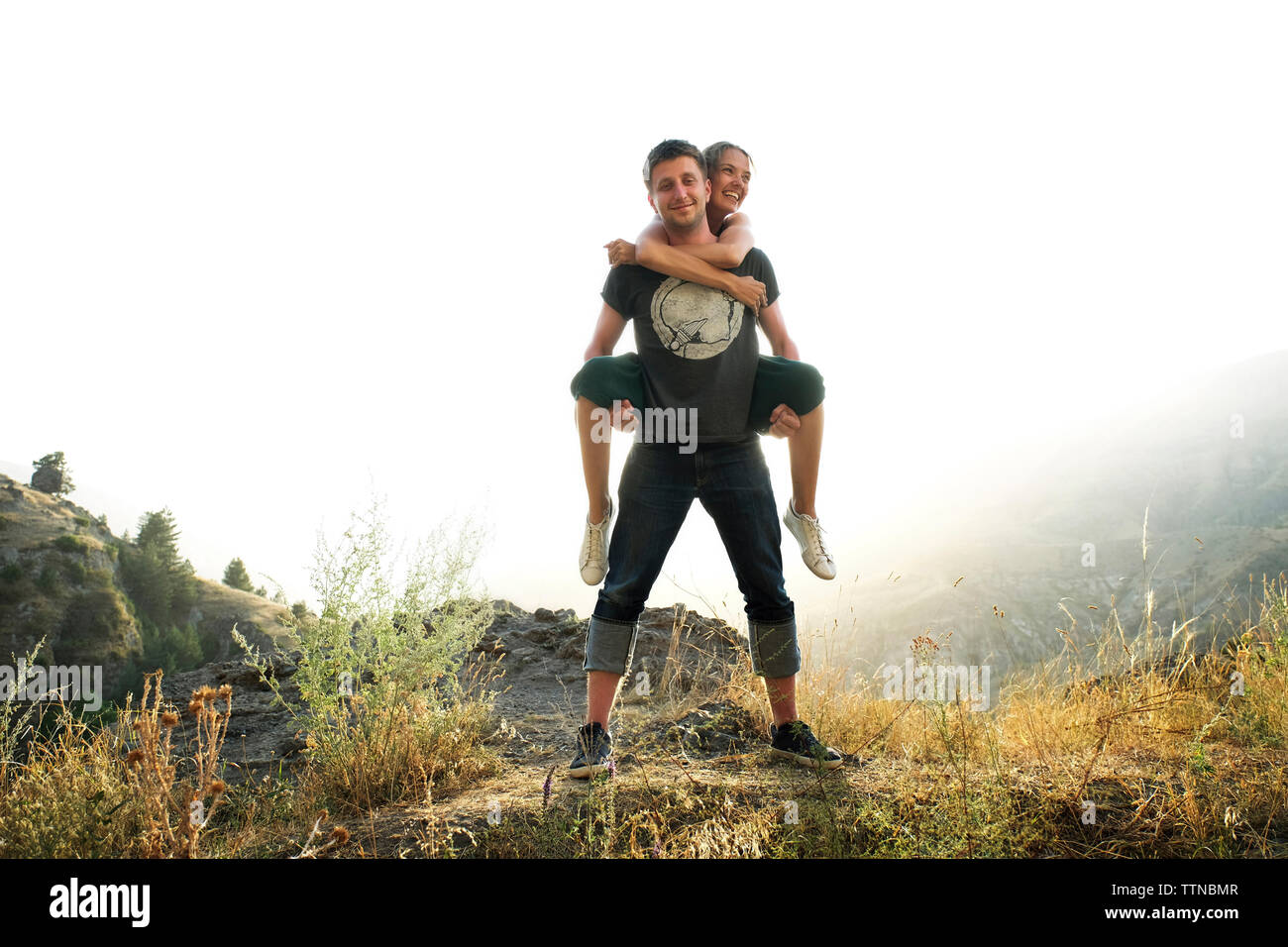 Portrait von Freund huckepack Freundin gegen Sky Stockfoto