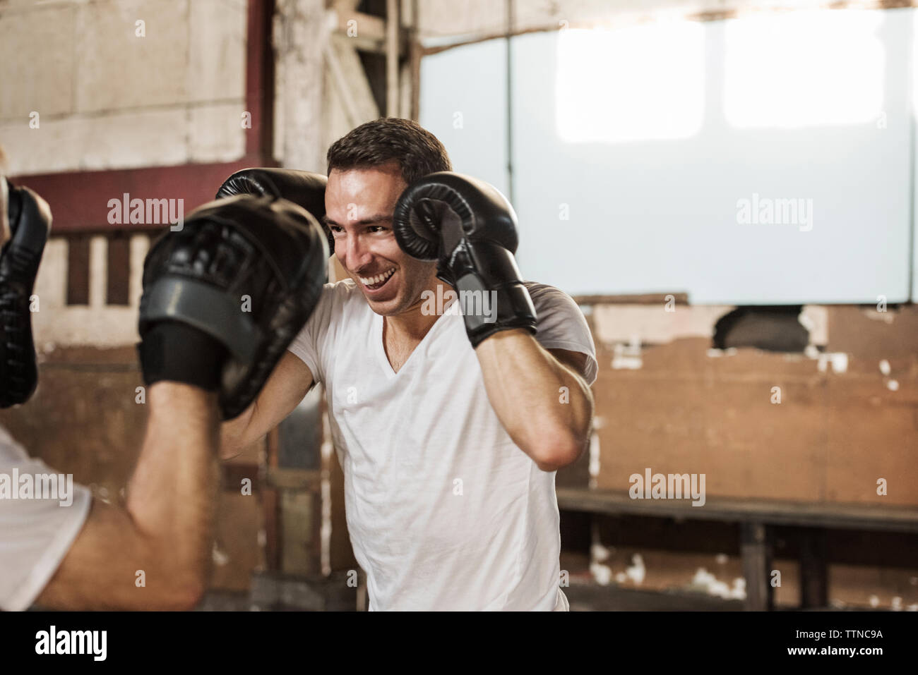 Gerne männliche Boxer üben mit älterer Mann in der Turnhalle Stockfoto