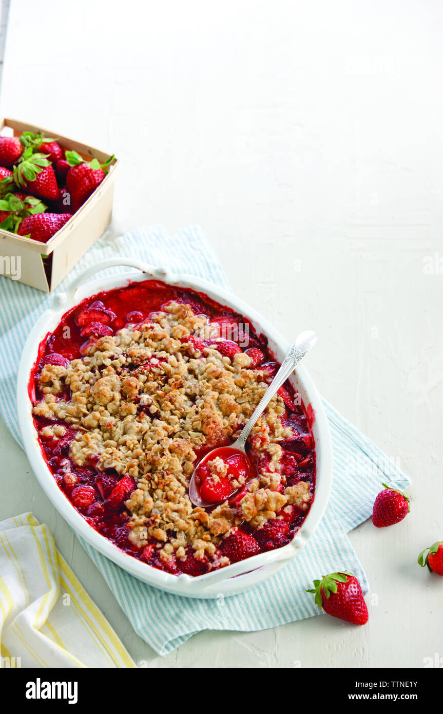 Hochwinkelansicht des Dessert in Behälter mit Erdbeeren und Serviette auf dem Tisch Stockfoto