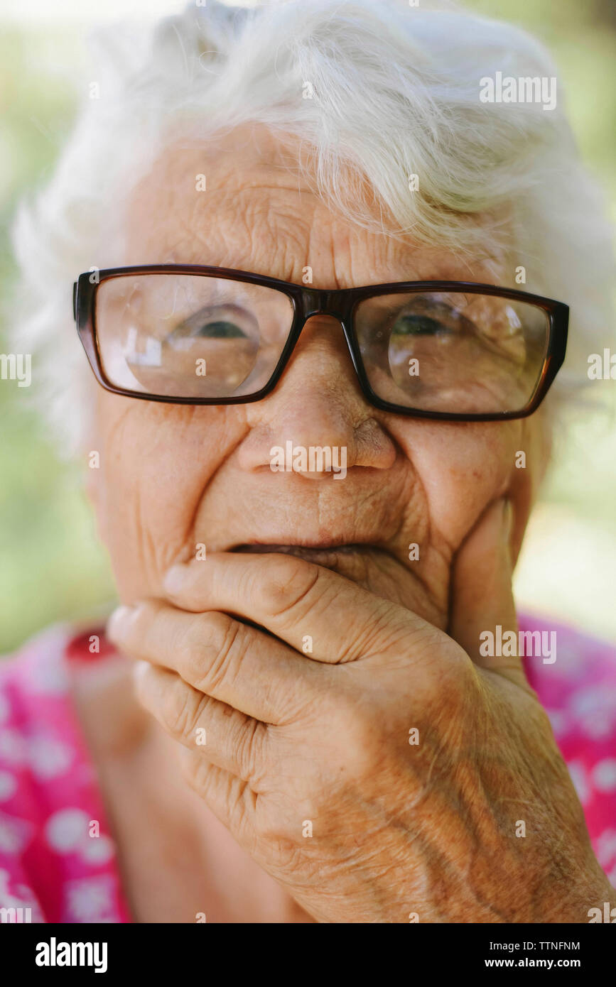 Close-up von nachdenklich ältere Frau mit der Hand am Kinn Brillen tragen Stockfoto