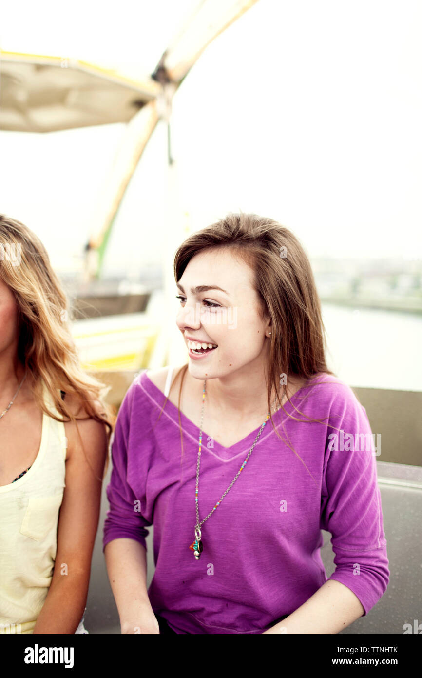 Happy Teenager auf der Suche nach Freund während der Sitzung in Fahrt am Vergnügungspark Stockfoto