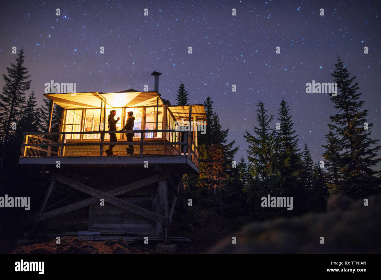 Low Angle View von Frauen stehen in beleuchtete Hütte bei Nacht Stockfoto