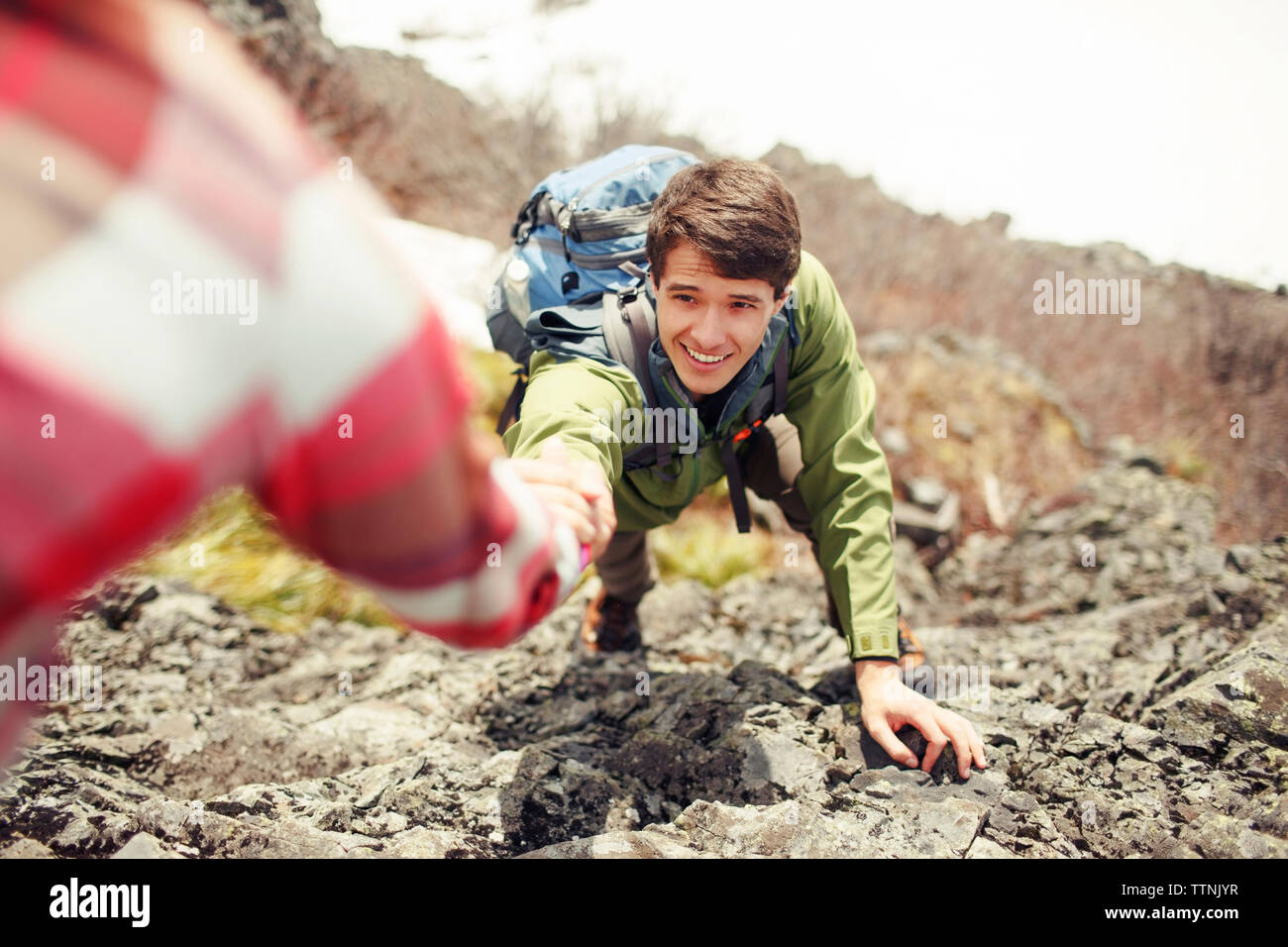 7/8 Bild der Frau Unterstützung männlicher Freund im klettern Berg Stockfoto