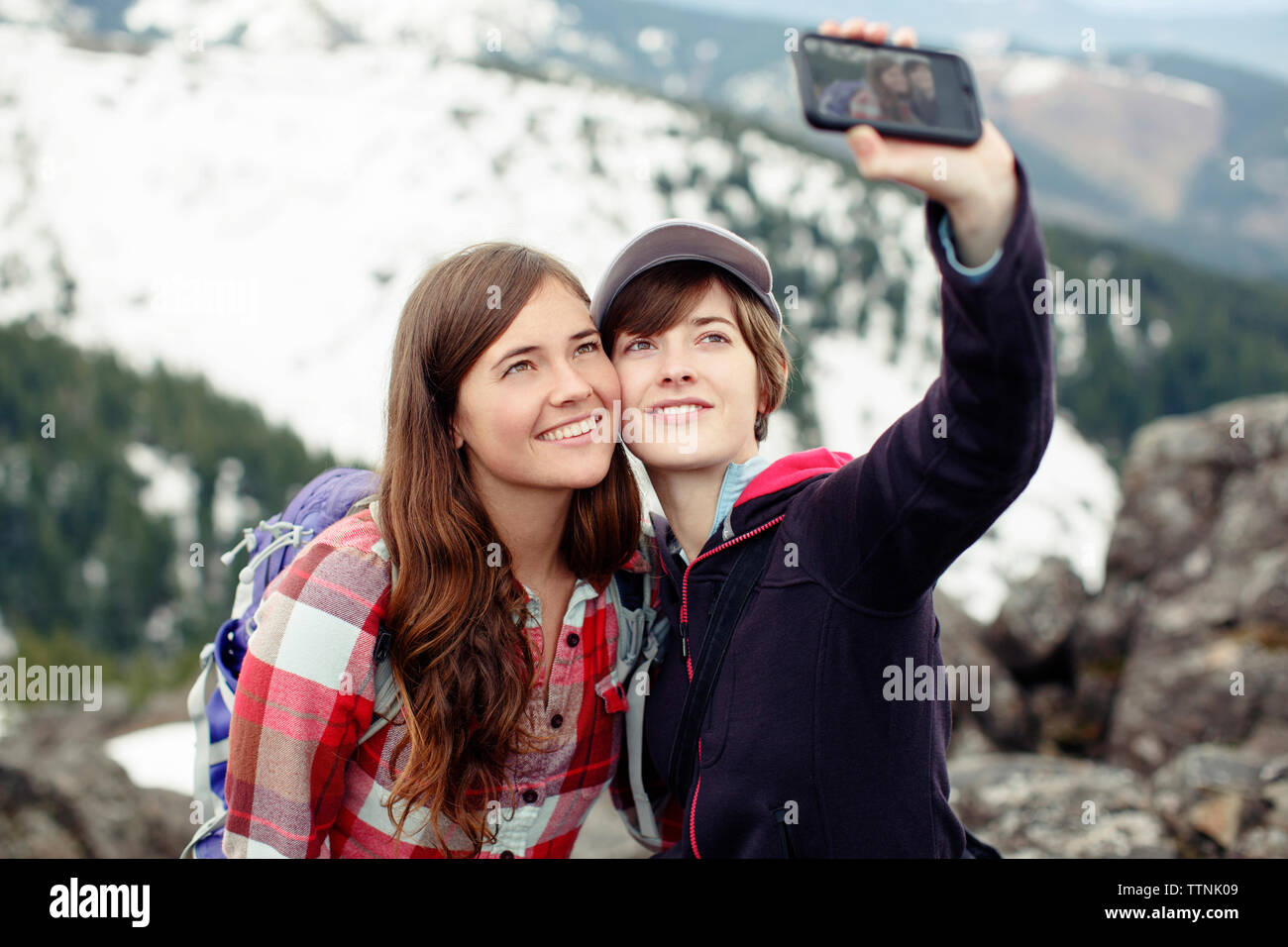 Weibliche Freunde unter selfie beim Stehen auf Berg Stockfoto