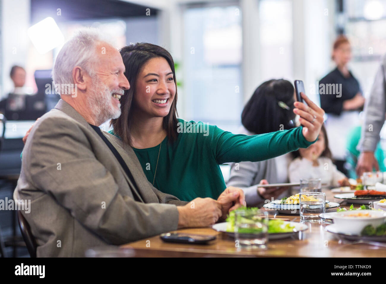 Frau unter selfie mit älterer Mann im Restaurant Stockfoto